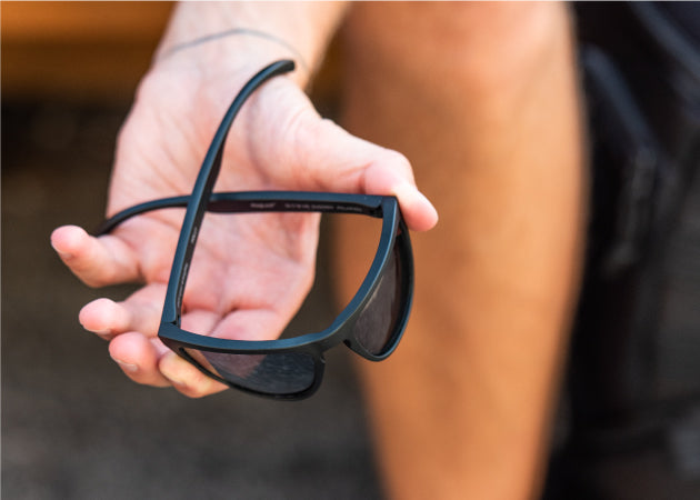 A flexible pair of Folly MagLock Sunglasses being bent in someone's hands